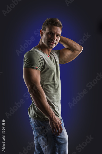 Handsome muscular fit young man, looking at camera with a smile