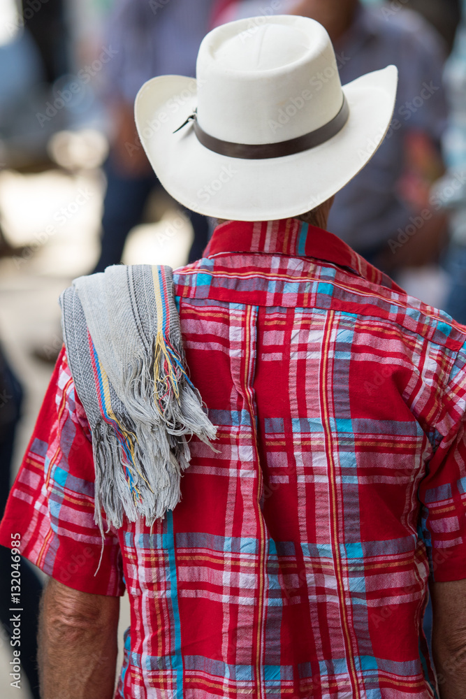 man wearing traditional Colombian straw hat and poncho over his sholder in the coffee town of El Jardin