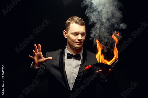 Young brunette magician in costume performing flame tricks