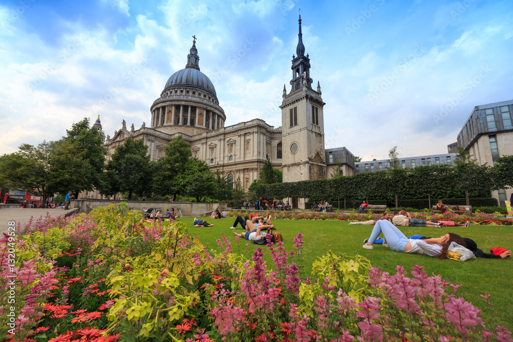 London, England - Jul 12, 2014 : People are spending their vacation in the small park at St.Paul Cathedral.