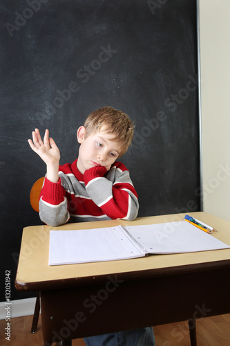 Tired student raising his hand halfheartedly photo