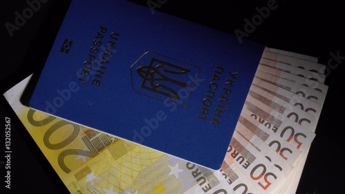 Euro banknote in the passport are rotated on the black desk photo