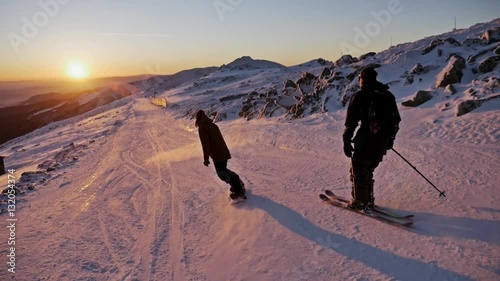 Wallpaper Mural Slowmotion footage of a skier and snowboarder riding the slope during a beautiful sunset. Torontodigital.ca