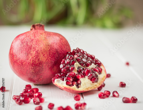 Ripe pomegranate seeds on a white wooden table. Fruit diet. Healthy lifestyle.