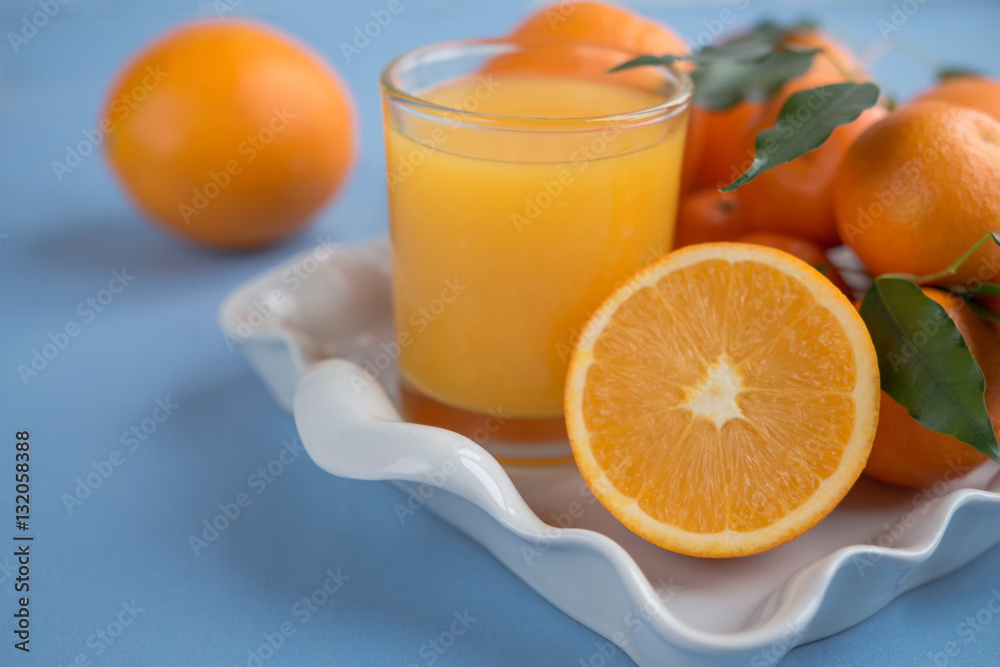 Fresh orange juice in a glass on a background of fruit baskets Fresh orange juice in a glass on a background of fruit baskets