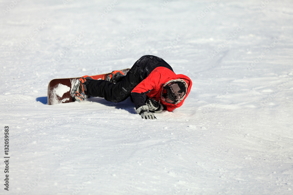 Dorosły mężczyzna leży na śniegu z deską snowboardową. - obrazy, fototapety, plakaty 