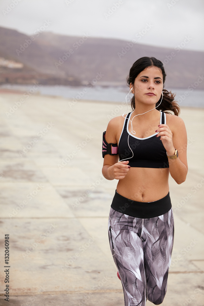 Fototapeta premium Young brunette jogging on the beach