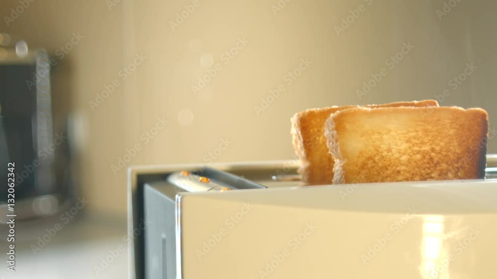 Roasted toast bread popping up from toaster machine with smoke. 4K