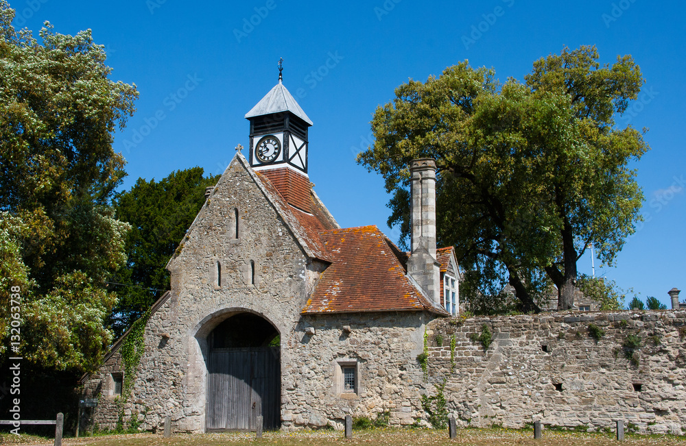 Ancient English Abbey walls with Its Gatehouse entrance and Tudor style clock tower in Beaulieu in Hampshire England