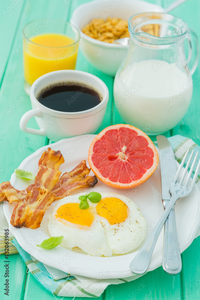 Fototapeta premium Summer breakfast - eggs, bacon, toast, jam, coffee, juice