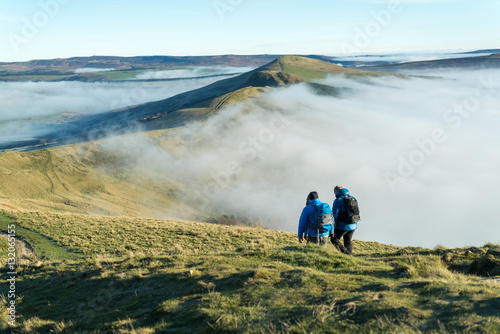 Male and female hikers walk along the great ridge along from Mam Tor, Peak District, Hope Valley on a cold winter morning photo