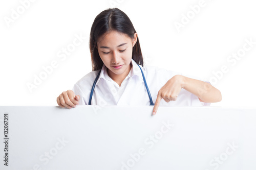 Young Asian female doctor point and look down to blank sign.