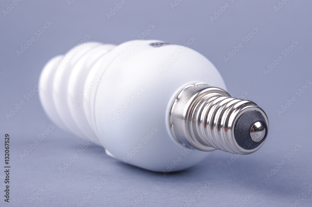 Compact fluorescent energy saving light bulb isolated on the gray background Compact fluorescent energy saving light bulb isolated on the gray background