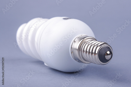 Compact fluorescent energy saving light bulb isolated on the gray background