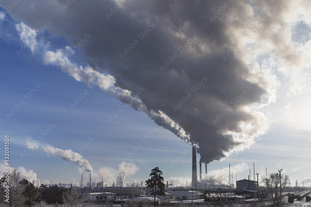 Smoking chimney of industrial buildings complex.