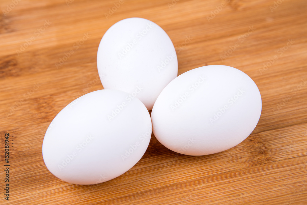 Whole white eggs isolated on a wood background Whole white eggs isolated on a wood background