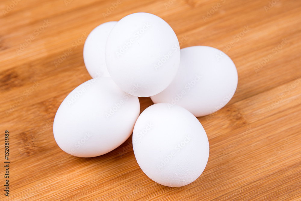 Whole white eggs isolated on a wood background Whole white eggs isolated on a wood background