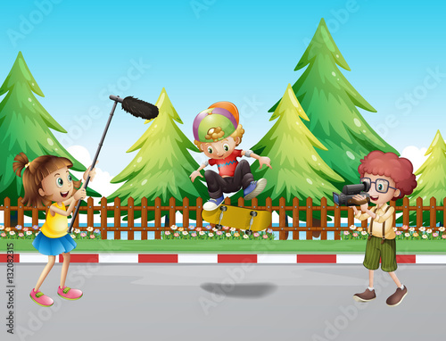 Children shooting boy playing skateboard