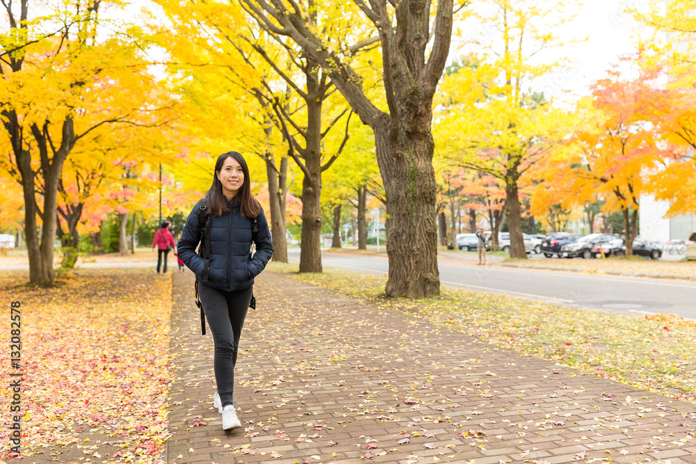 Fototapeta premium Woman walking at outdoor with gingko tree plant