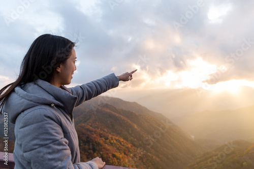 Woman finger pointing to sunset photo