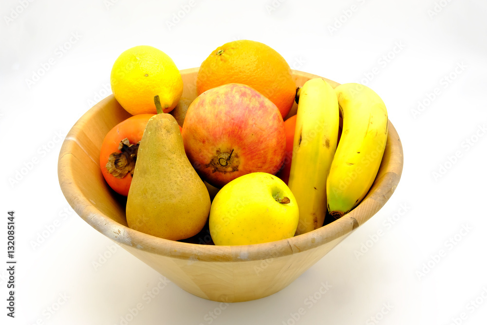 Fruit bowl with orange, lemon, pear, persimmon, bananas, kiwi an