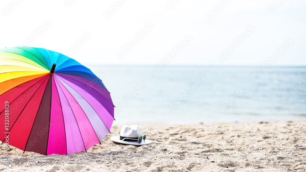 Beach colorfull umbrella on a sunny day, sea in background, select and soft focus
