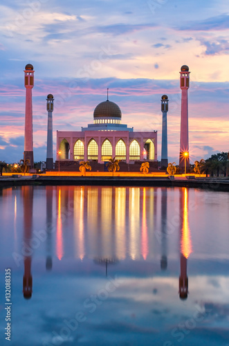 silhouette central mosque songkhla Thailand with sun flare effect and colorful sky background on sunset time and water reflection.