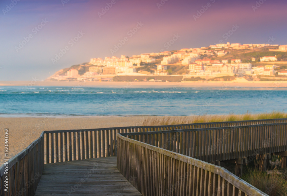 Wooden walking path at the beach. View of the lagoon of Obidos, the city of Foz do Arelno. Portugal