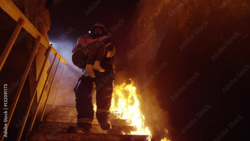 Brave Fireman Descends Burning Stairs with Saved Little Girl in His Hands. Open Flames are Seen Everywhere.  Shot on RED EPIC (uhd).