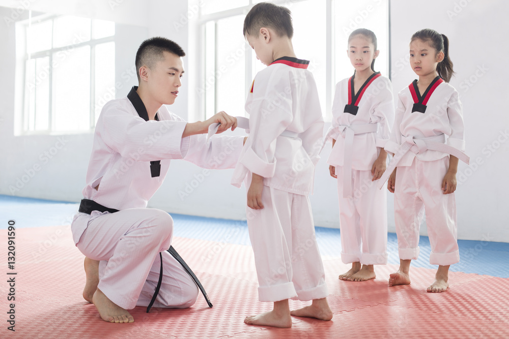 Young instructor teaching children Tae Kwon Do Young instructor teaching children Tae Kwon Do