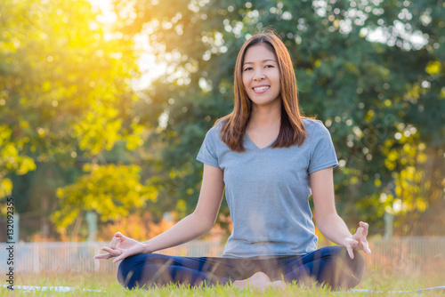 Young asian smiling woman practicing yoga, sitting in easy pose, healthy woman. Concept of healthy lifestyle and relaxation