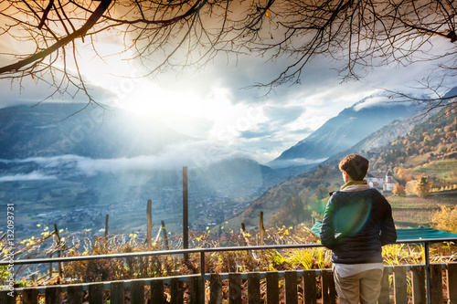 Traveler woman admiring a landscape with mountain valley in the