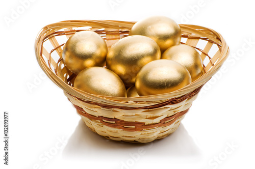 golden eggs in a basket isolated on white background