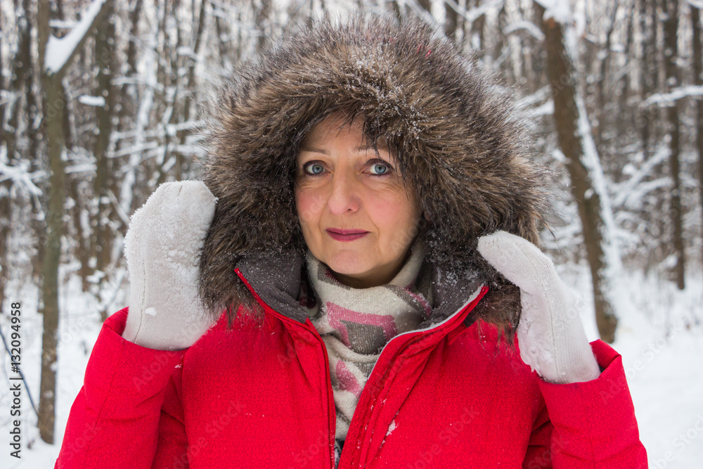 Portrait of a nice senior woman in the winter snow wood in red coat Portrait of a nice senior woman in the winter snow wood in red coat
