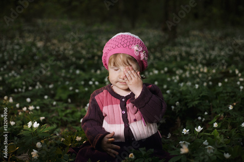 beautiful little girl in forest on flowers field