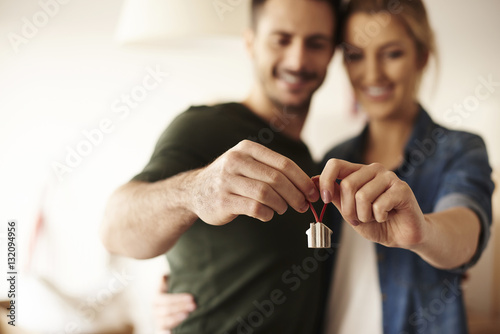 Couple holding key ring to their new house .