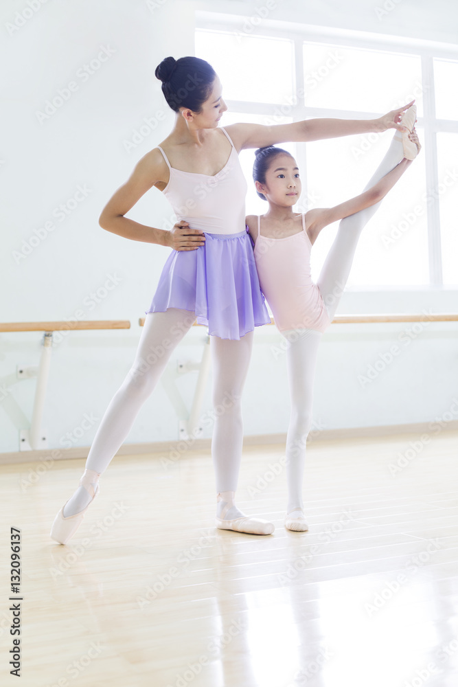 Young ballet instructor teaching girl in ballet studio Young ballet instructor teaching girl in ballet studio