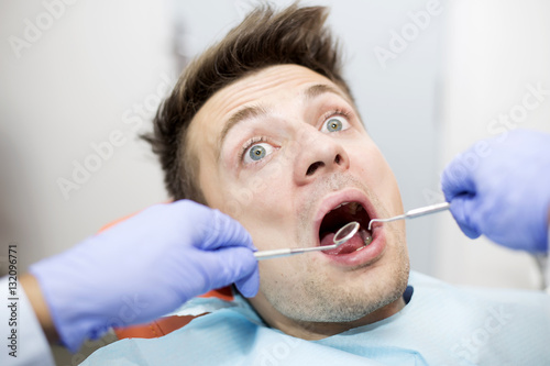 Scared young man at dentist office