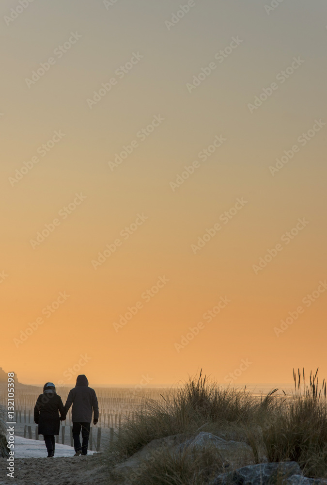 Couple d'amoureux sur la plage un soir d'hiver