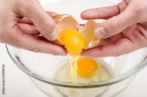 one fresh egg is broken and placed in a glass bowl