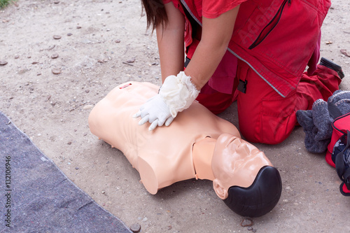 Female paramedic showing cardiopulmonary resuscitation - CPR on training doll. First aid training.