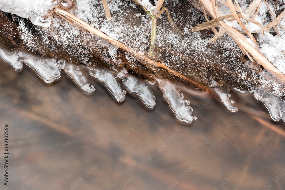 Thin layers of ice forming on the side of a freezing stream. Thin layers of ice forming on the side of a freezing stream.