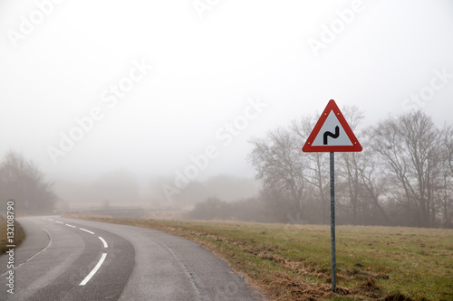 foggy road with warning sign