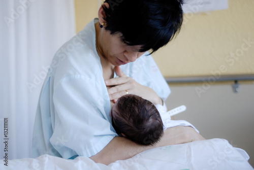 Mother feeding breast her newborn baby at the hospital.