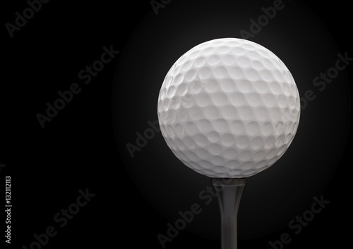 Golf ball on tee on black background.