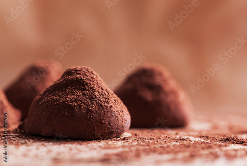 Chocolate truffles with sweet cream inside on the wooden background 