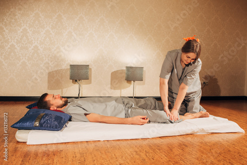 woman making thai massage to a man