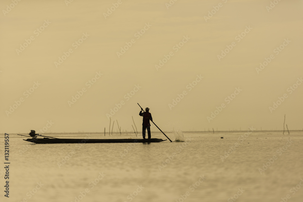 Oarsman fishing The lifestyle of Thailand. Silhouette at dawn Fisher morning.
