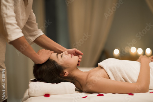 Masseuse giving a facial massage to a woman in a spa photo