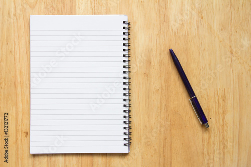 Blank paper note book with pen on wood table background